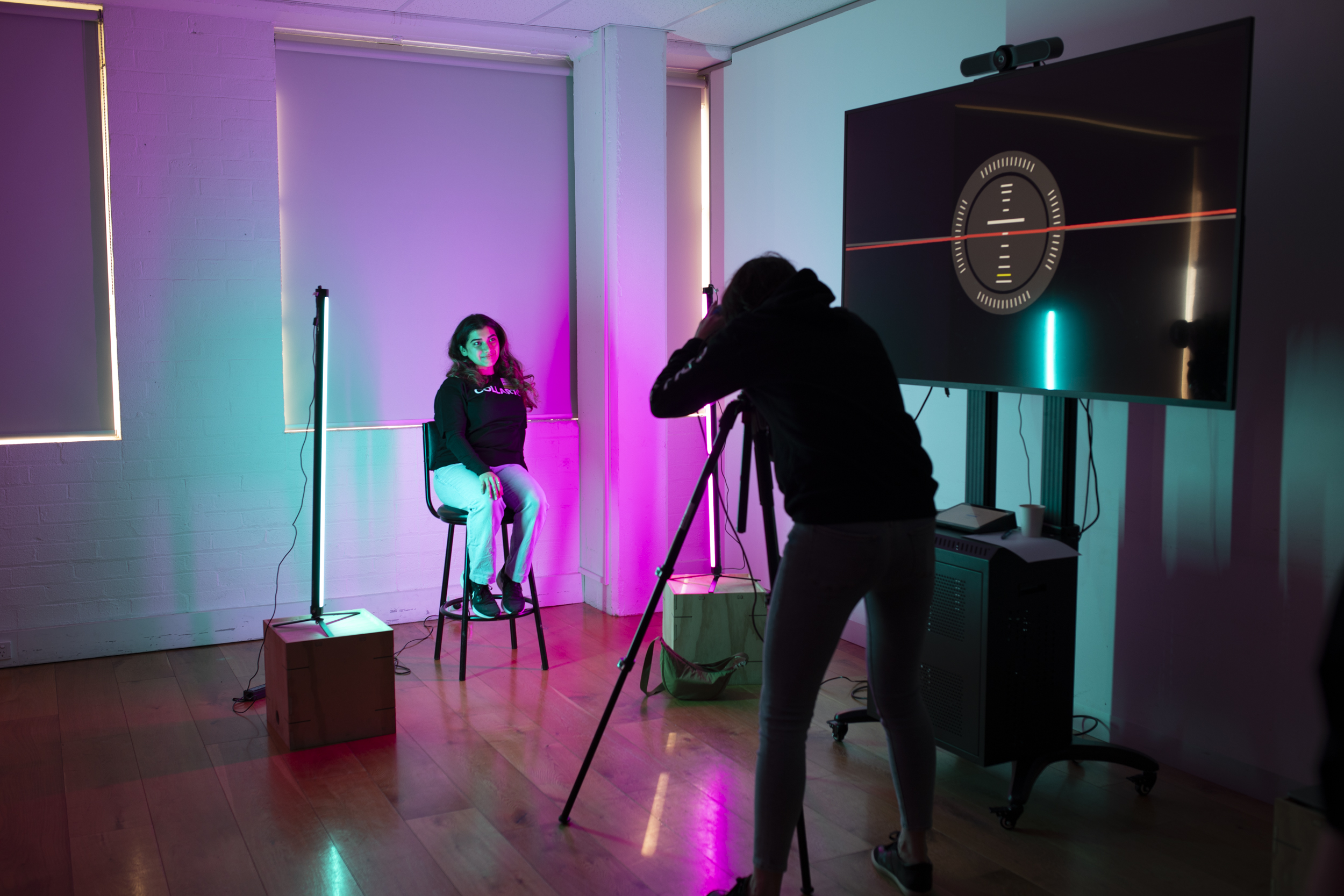 Collarts photography student taking a portrait photo of a person with blue and purple lights lighting the frame