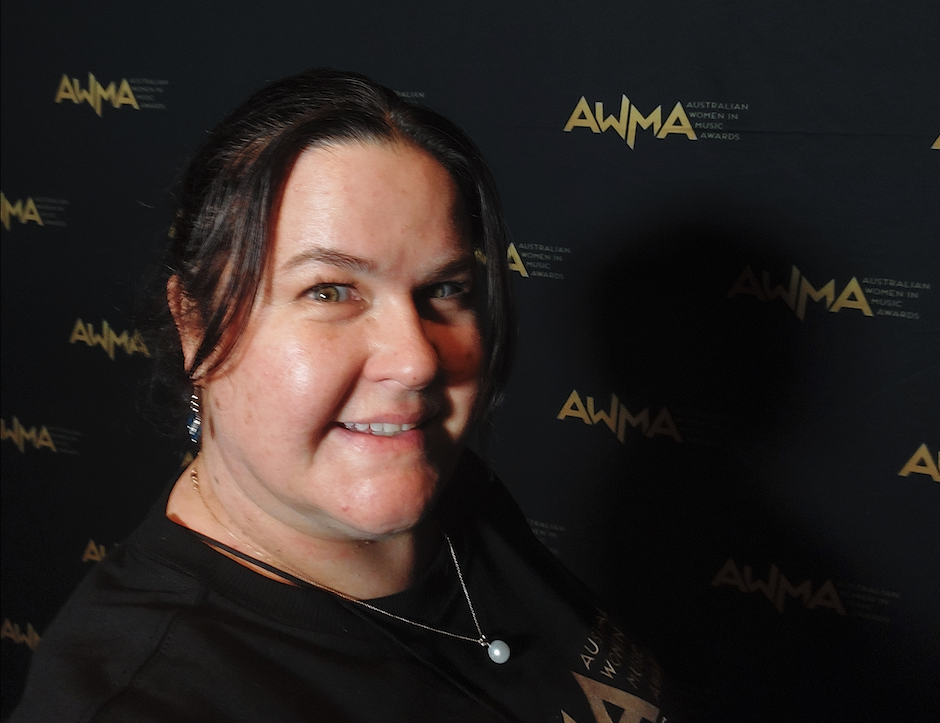 Collarts student smiling in front of media wall at Australian Women in Music Awards 2025