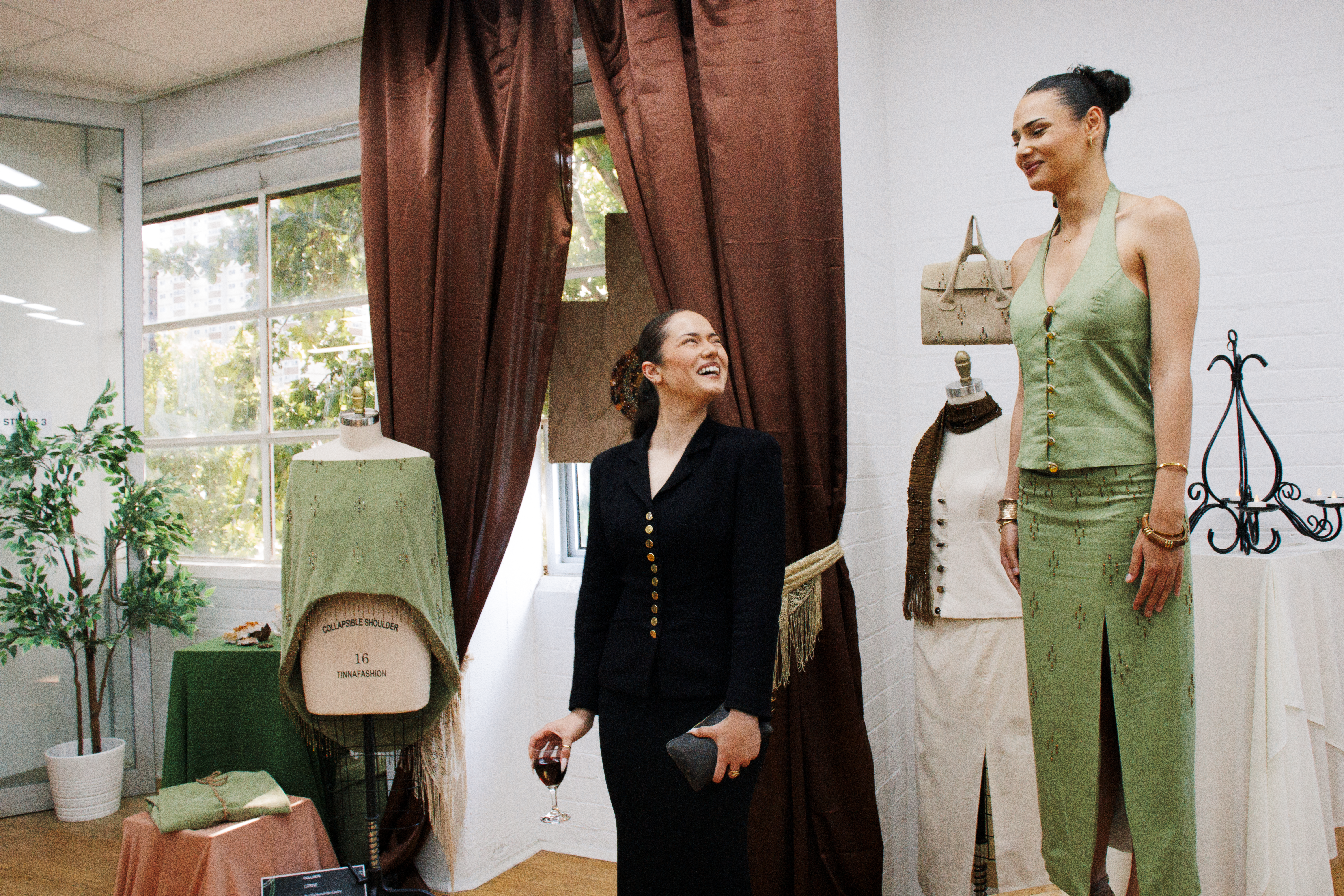 Collarts fashion student smiling and looking up at her model wearing an outfit she created